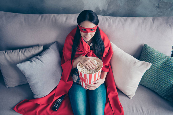 High angle top above photo beautiful she her superpower lady costume hold popcorn container watch premiere new long wait comics picture wear red eye mask mantle sit sofa couch divan house indoors - Foto, imagen