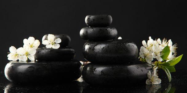 Spa stones and white flowers isolated on black - Foto, imagen