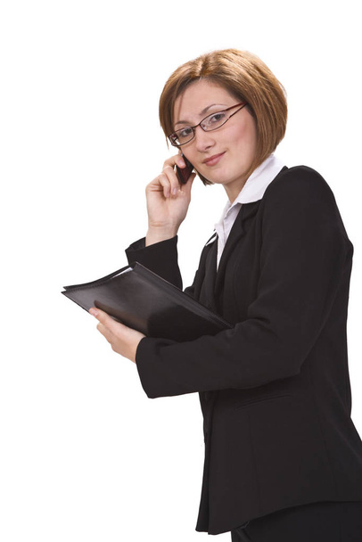 Young businesswoman on the phone, carrying a wallet, isolated against a white background. - Photo, image