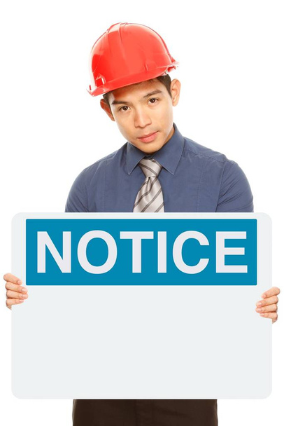 A man wearing a hardhat and holding a blank notice or safety sign - Φωτογραφία, εικόνα