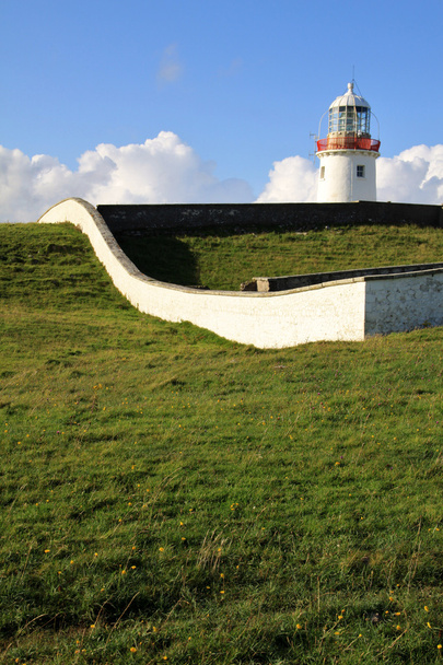 weißer Leuchtturm auf einem grünen Hügel, irland - Foto, Bild