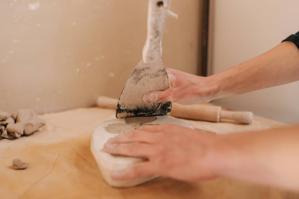 Mains d'un potier créant un élément de décoration à l'aide d'une argile. Gros plan des mains masculines
 - Photo, image