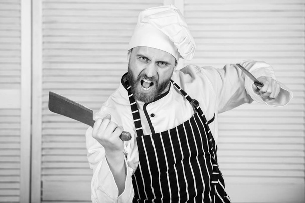 Chef with knifes. Professional in kitchen. culinary cuisine. angry bearded man with knife. love eating food. confident man in apron and hat. cook in restaurant, uniform. chef ready for cooking - Photo, Image