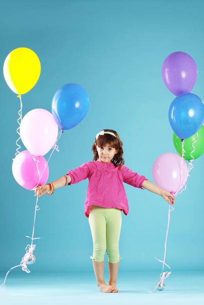 Child with colorful air ballons over blue - Foto, Bild