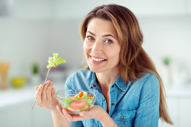 Close-up portrait of her she nice-looking lovely charming cute attractive shine cheerful cheery positive brown-haired lady tasting detox vitamin salad in light white interior style kitchen - Fotografie, Obrázek