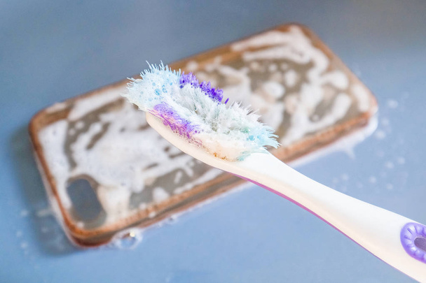 A szilikon telefontok tisztítása fogkefével, habbal és szappannal - Fotó, kép