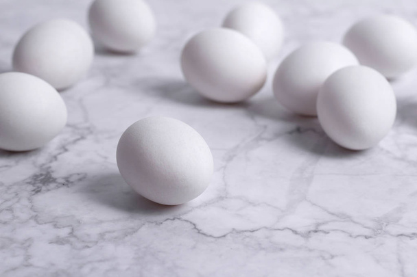 Stylish Set of white eggs on white marble background. - Zdjęcie, obraz