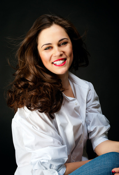 Portrait de jeune femme souriante aux cheveux longs en jeans et en blanc
 - Photo, image