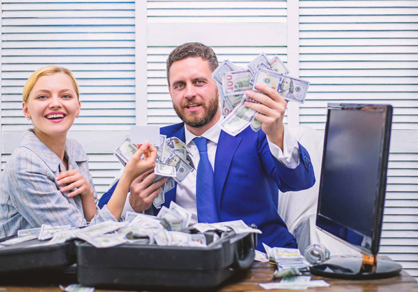 Handsome man happy and surprised with money hundreds dollars in case. Young businessman looking at money scattered on table. Profit and richness concept. - Fotoğraf, Görsel
