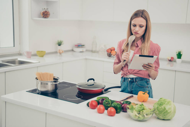 Close up photo beautiful amazing she her lady hold hands arms e-reader unsure uncertain doubtful recipe true homey wear domestic home apparel shirt jeans denim outfit bright flat home kitchen indoors - Fotó, kép