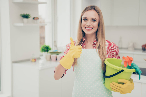 Close up photo beautiful busy nice duties she her lady stand bright shiny kitchen house housemaid finished work okey symbol thumb up hold work supplies wear casual jeans denim shirt cute apron flat - Photo, image