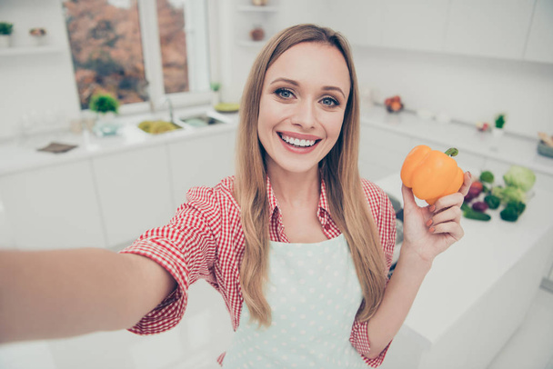 Közelről fotó szép lány hölgy főzés háziasszony kész készítmények finom edényt, hogy vegye selfies tartsa paprika társadalmi konyha blogger kopás hazai kötény ing fényes otthoni konyha beltéri - Fotó, kép