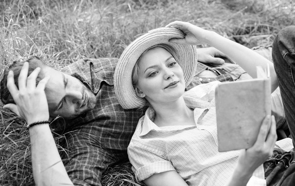 Man and girl lay on grass reading book. Family enjoy leisure with poetry or literature book grass background. Couple soulmates at romantic date. Couple in love spend leisure reading book in park - Foto, Imagen