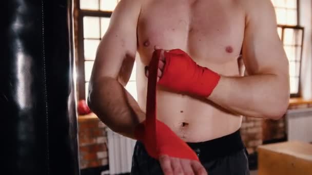 Egy férfi az edzőteremben üzembe kötszerek a kezét, mielőtt boksz - Felvétel, videó