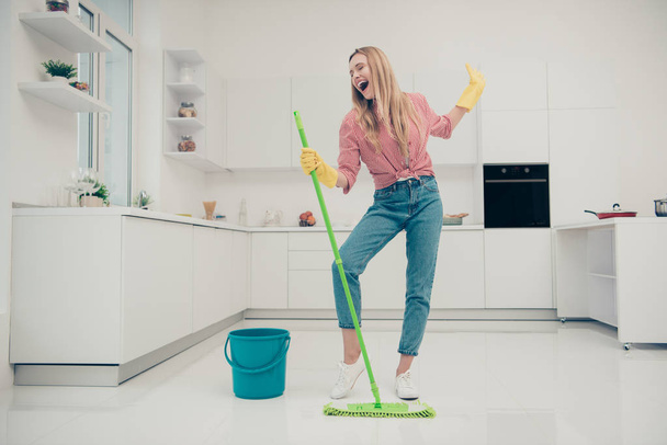 Full length body size photo beautiful amazing funky she her lady wash white floor housemaid karaoke day singing mop crazy movement wear jeans denim casual plaid checkered shirt bright light kitchen - Photo, Image