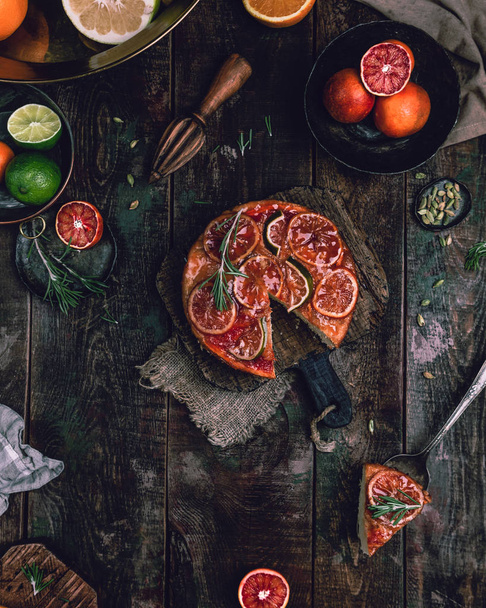 fresh homemade pie with sicilian oranges and rosemary twigs on old wooden table - Fotografie, Obrázek