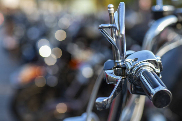 The chromed handlebar of a motorcycle.  View of motorcycle handlebar in the background many motorbikes blurred.  - Photo, Image