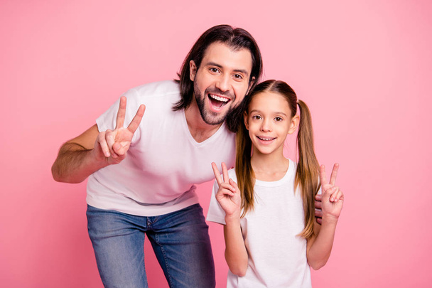 Close up photo beautiful she her little lady stand he him his single dad show v-sign say hi pretty hairstyle vacation rest relax wear casual white t-shirts denim jeans isolated pink bright background - Foto, afbeelding