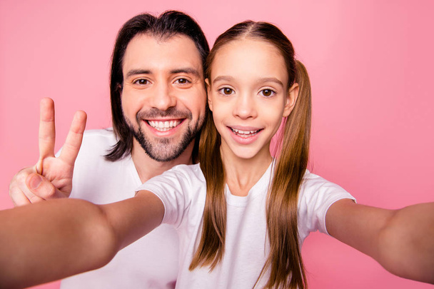 Close up photo beautiful she her little small lady he him his single dad daddy make take selfies show v-sign say hi mom mommy wear casual white t-shirts denim jeans isolated pink bright background - Foto, Imagem