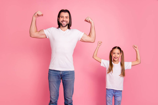 Close up photo beautiful she her little small lady he him his daddy showing muscular hands arms fists one team teamwork winners wear casual white t-shirts denim jeans isolated pink bright background - Photo, Image
