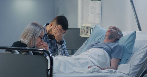 Man lying in hospital among family - Photo, Image
