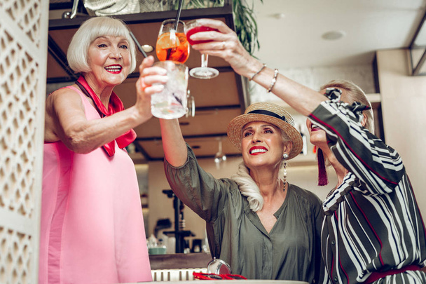 Happy nice aged women clinking their glasses - Valokuva, kuva