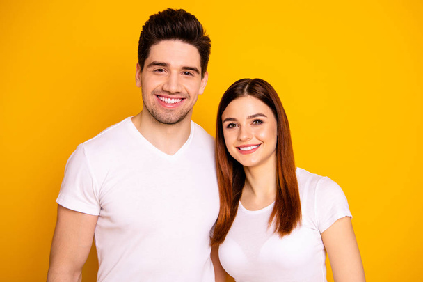 Close up photo funny amazing beautiful she her he him his guy lady standing hugging sincere beaming smile easy-going best fellows buddies wear casual white t-shirts outfit isolated yellow background - Fotó, kép