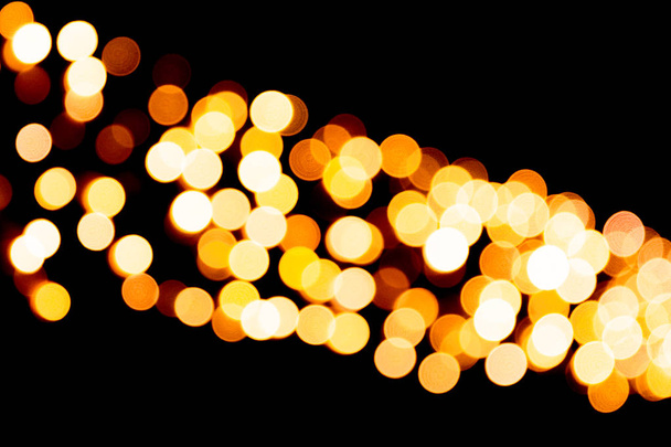 Εορταστική αφηρημένη χρυσό φόντο με bokeh defocused και θολή πολλά στρογγυλό, κίτρινο φως σε σκούρο φόντο χριστουγεννιάτικο - Φωτογραφία, εικόνα