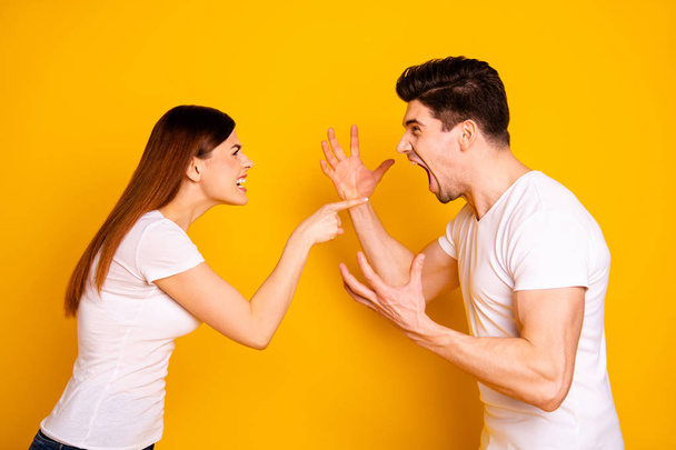 Profile side view portrait of his he her she two attractive angry aggressive nervous annoyed irritated people having fight anger blame isolated over vivid shine bright yellow background - Фото, изображение