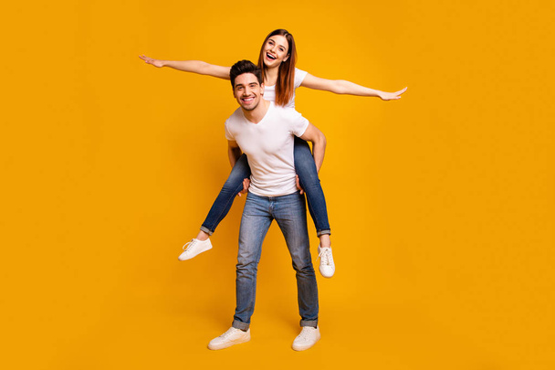 Full length body size view portrait of his he her she two nice attractive cheerful optimistic careless carefree people wife husband having fun isolated over vivid shine bright yellow background - Фото, зображення