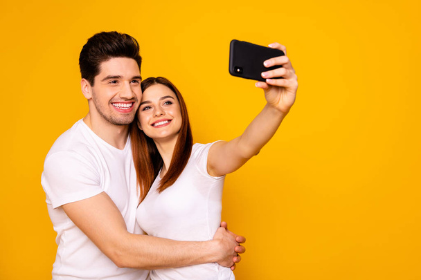 Portrait of his he her she two nice attractive lovely cheerful cheery positive people making taking selfie enjoying free time isolated over vivid shine bright yellow background - Fotó, kép