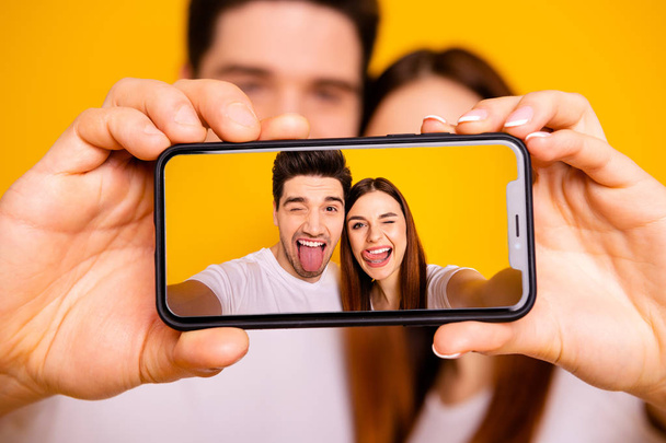 Close-up view portrait of two nice attractive lovely cheerful cheery playful foolish positive people making taking selfie isolated over vivid shine bright yellow background - Valokuva, kuva