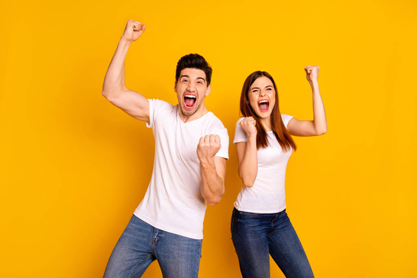 Portrait of two nice attractive lovely adorable charming cheerful cheery crazy ecstatic people having fun lottery win winner best lucky isolated over vivid shine bright yellow background - Photo, Image