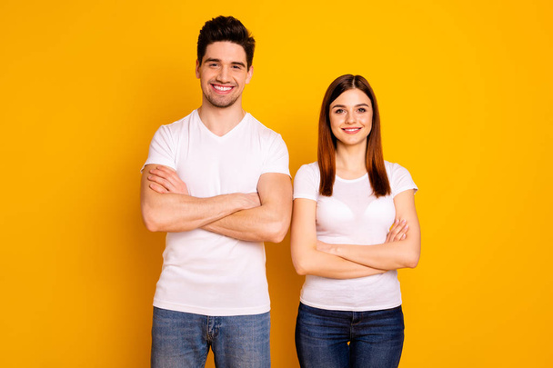 Close up photo beautiful cheer she her he him his pair stand side teamwork self-confident professionals specialists work job reliable workers wear casual white t-shirts isolated yellow background - Фото, зображення