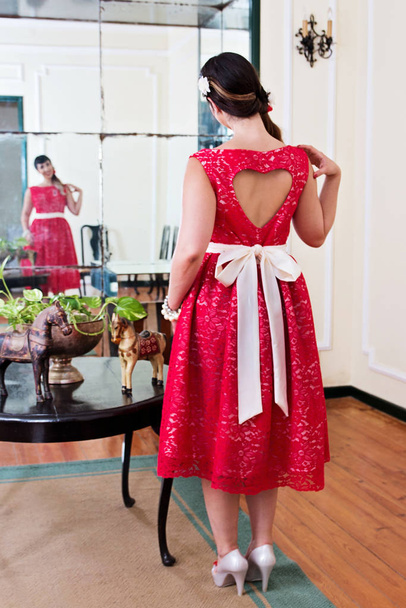 Pinup girl with red dress posing on a vintage home. - Foto, Imagem