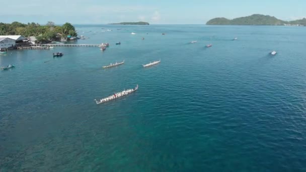 Aérea: kora-kora tradicional carrera anual en canoa en Bandaneira en el hermoso mar de las Islas Banda, Maluku, Indonesia. Perfil de color D-log cinelike nativo
 - Metraje, vídeo