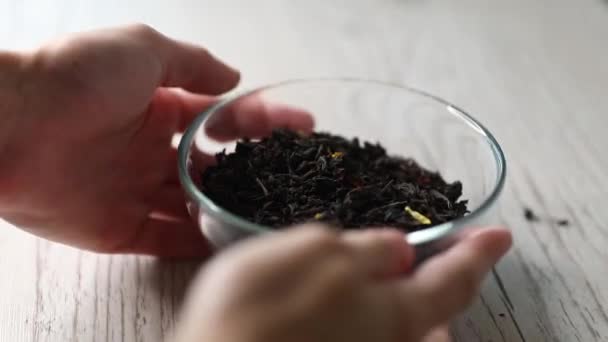 Dry flavoured black tea on a wooden background. Close-up, copy space. - Video