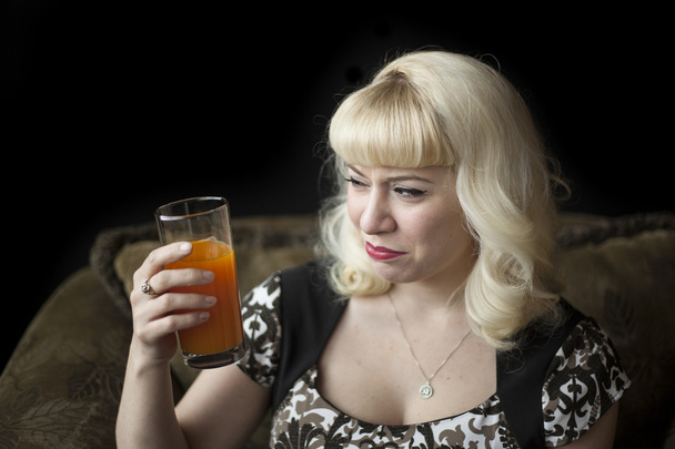 Beautiful Young Woman with Blond Hair Drinking Mango Juice - 写真・画像
