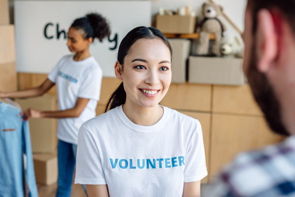 enfoque selectivo de jóvenes, voluntarios bastante multiculturales que trabajan en el centro de caridad
 - Foto, Imagen