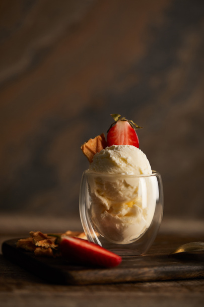 вкусное мороженое с клубникой и кусочком вафли на доске
 - Фото, изображение
