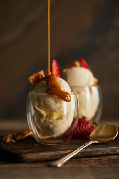 pouring caramel and delicious ice cream in glass on chopping board - Photo, Image