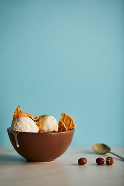 bowl of delicious scoops of ice cream with pieces of waffle on blue with copy space - Fotografie, Obrázek