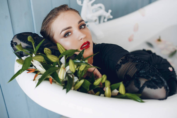 Stylish and beautiful girl lies in the bathroom - Foto, imagen