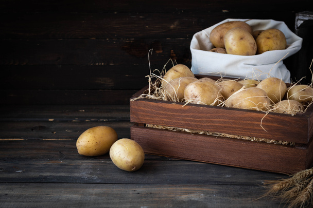 Органічна сировинна картопля в дерев'яній решеті в соломі - Фото, зображення