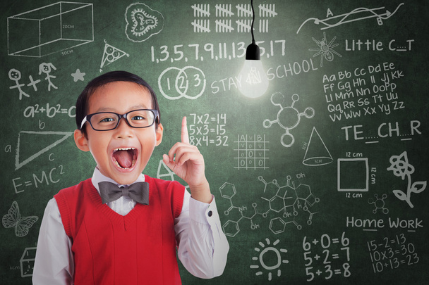 Asian boy has idea under lit bulb in classroom - Zdjęcie, obraz