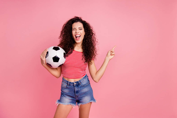 Portrait of her she nice cool attractive lovely charming cheerful cheery ecstatic wavy-haired girl holding in hands ball pointing aside advert ad isolated over pink pastel background - Foto, Bild