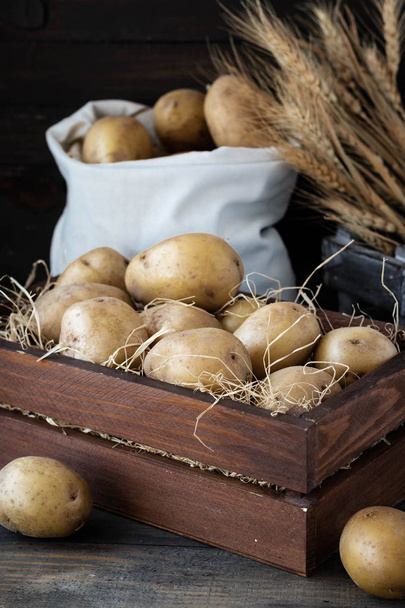 Органічна сировинна картопля в дерев'яній решеті в соломі - Фото, зображення