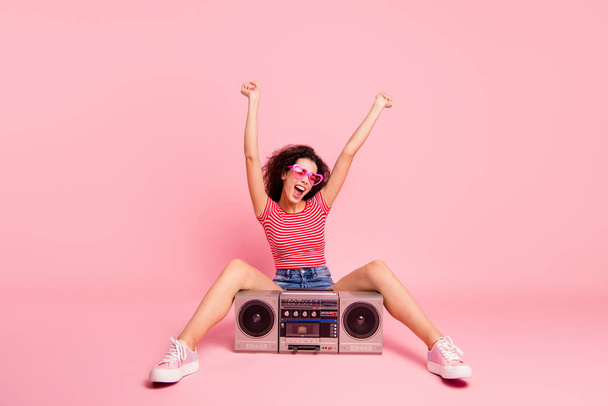 Portrait of her she nice cool attractive lovely crazy cheerful cheery wavy-haired lady sitting with player night club clubber nightlife raising hands up celebrate isolated over pink pastel background - Valokuva, kuva