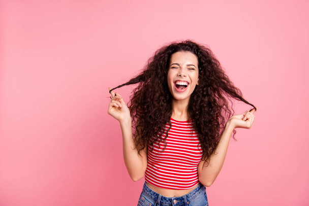 Closeup photo portrait of positive pretty glad optimistic cheerful joking grimacing she her lady holding curls in hands isolated pastel pop background - 写真・画像