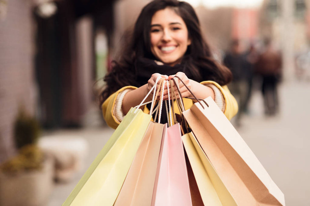 Mujer estirando bolsas de compras a la cámara, primer plano
 - Foto, imagen